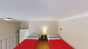 A small, single-room accommodation with two single beds, a nightstand, and a ceiling light. - Loft Galileo · Design in the Heart of Monza (Monza)