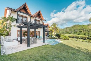 Ein zweistöckiges Haus mit Pool, Außenbereich und Garten.