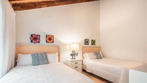 A hotel room with two beds, a nightstand with a lamp, and wall art. - 3br 10 guests ocean view  Bbq in Samana (Sánchez)