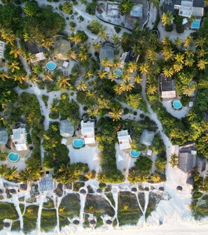 Eine Luftaufnahme eines Resorts mit mehreren Schwimmbecken, Palmen und verschiedenen Gebäuden.