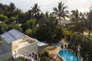 Ein Resort mit Pool, Sitzgelegenheiten im Freien und Meerblick.