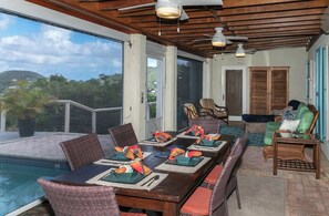 A spacious outdoor dining area with a pool, wooden ceiling, and large windows overlooking a lush landscape. - Cielo Vista-Sunset Views, Private Pool, AC, Generator (Cruz Bay)