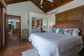 A bedroom with a large bed, wooden headboard, and a tiled floor. - Cielo Vista-Sunset Views, Private Pool, AC, Generator (Cruz Bay)