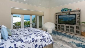 Een slaapkamer met een bed, een televisie en een balkon met tuinmeubilair.