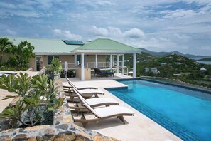 A resort with a swimming pool, lounge chairs, and a covered patio area. - Maria Bluff Main House- Modern Renovations, Private Pool, Ocean Front Views, and Pool Table! (Cruz Bay)