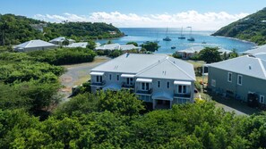 A residential area with houses, a clear view of the sea, and boats. - Pirates Villa- Beach view with kayaks for Groups (Cruz Bay)