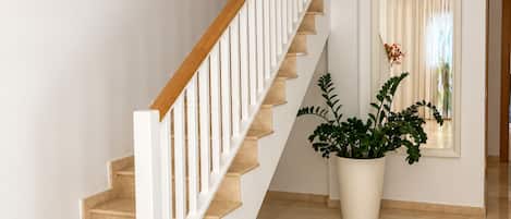 A staircase with white railings and beige steps leading to a landing.