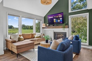 A modern living room with a large TV, comfortable seating, and a fireplace. - Golf Course Oasis·Hot Tub·Family Fun·Club Pool (Galena)