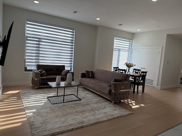 Ein geräumiges Wohnzimmer mit einer Couch, einem Couchtisch und einem Essbereich.