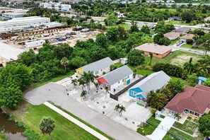 A residential area with houses, a parking lot, and a large industrial facility in the background. - Beach Breeze Bungalow (Fort Myers)