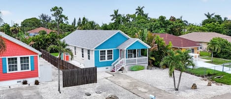 Un quartier résidentiel avec des maisons, une allée gravillonnée et un ciel dégagé.