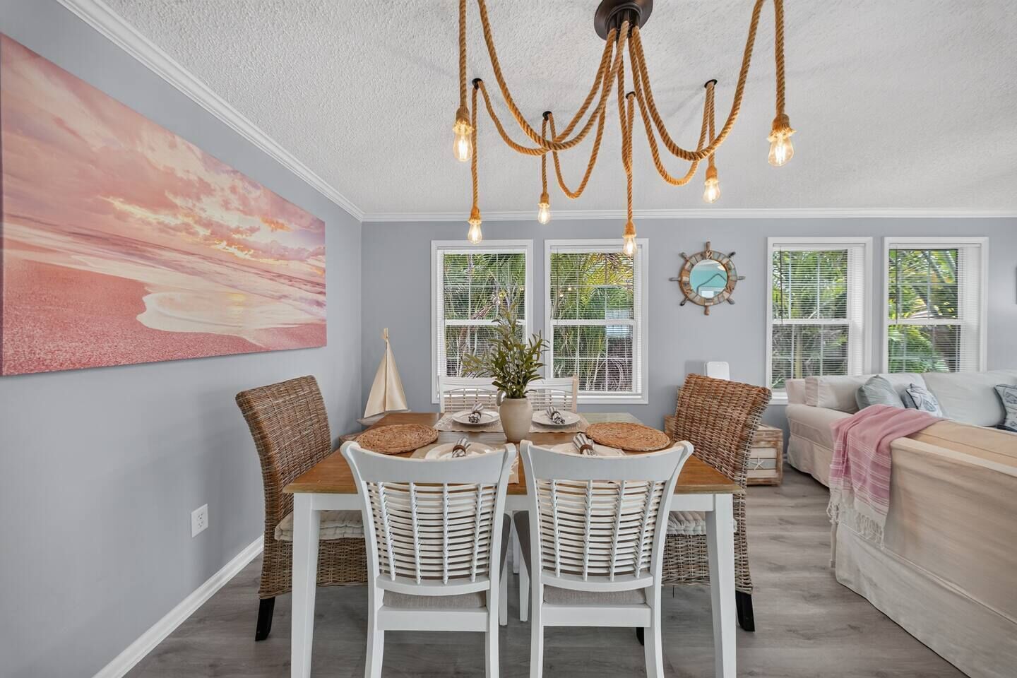 A dining area with a table, chairs, and a chandelier.