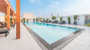 Una piscina sul tetto con lettini e piante in vaso.