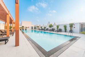 A rooftop swimming pool with lounge chairs and potted plants. - Free Housekeeping Visits During Your Stay - Stayshort - Contemporary 1 Bedroom Sleeps 4 in JVC (Dubai)