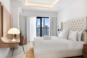 A modern hotel room with a large bed, a desk with a lamp, and a view of a cityscape. - Free Housekeeping Visits During Your Stay - Stayshort - Modern 2BR in Prime Business Bay 4 Guests (Dubai)