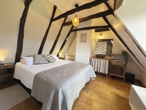 A bedroom with a bed, wooden beams, a hanging light fixture, a bedside table, and a small table with a mirror. - Marvelous 2-bedroom house with AC in charming Meyrals (Meyrals)