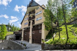 A multi-story building with balconies, a stone staircase, and surrounding greenery. - The Ridge | Family Apartment with Matterhorn View (Breuil-Cervinia)