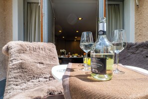 A bottle of Chateau Blanc wine, two glasses, and a fluffy chair on a table. - The Ridge | Family Apartment with Matterhorn View (Breuil-Cervinia)