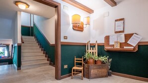 A staircase leading to a landing with a wooden chair and potted plants. - Cretaz Nest - Central Studio near Ski Lifts (Breuil-Cervinia)