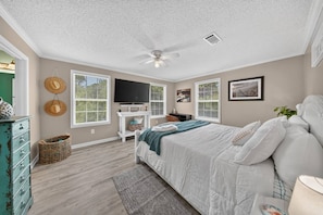 A bedroom with a bed, a TV, a ceiling fan, and a window. - 3BR/2BA Beach House! Sleeps 9 w/ 2 Living rms-W/D! (Fort Myers)