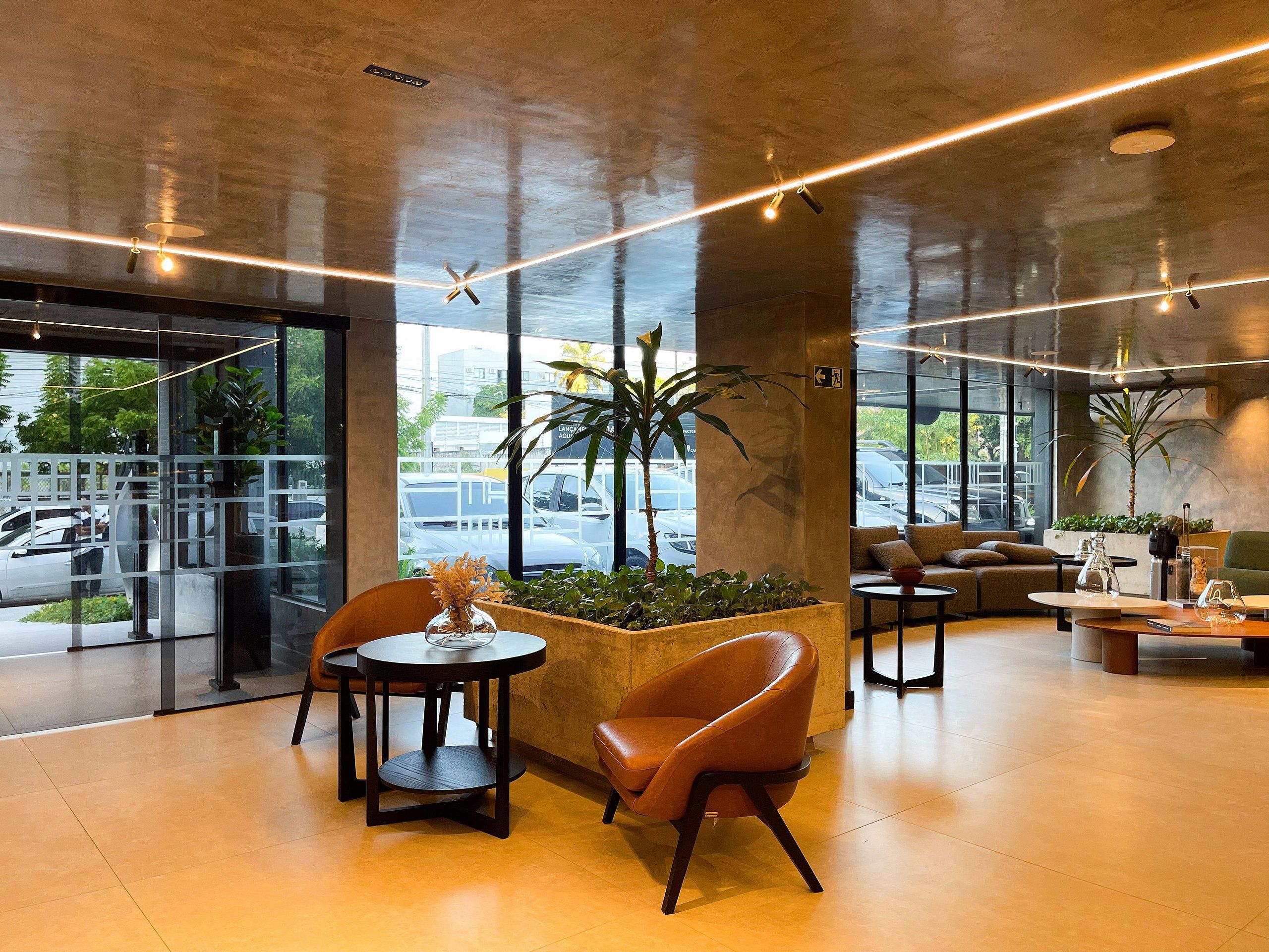 Um interior moderno com área de estar, mesa de centro e planta em vaso.