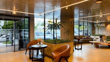 Um interior moderno com área de estar, mesa de centro e planta em vaso.