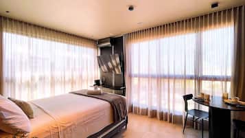 A hotel room with a bed, a desk, and a chair.