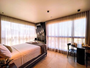 A hotel room with a bed, a desk, and a chair.