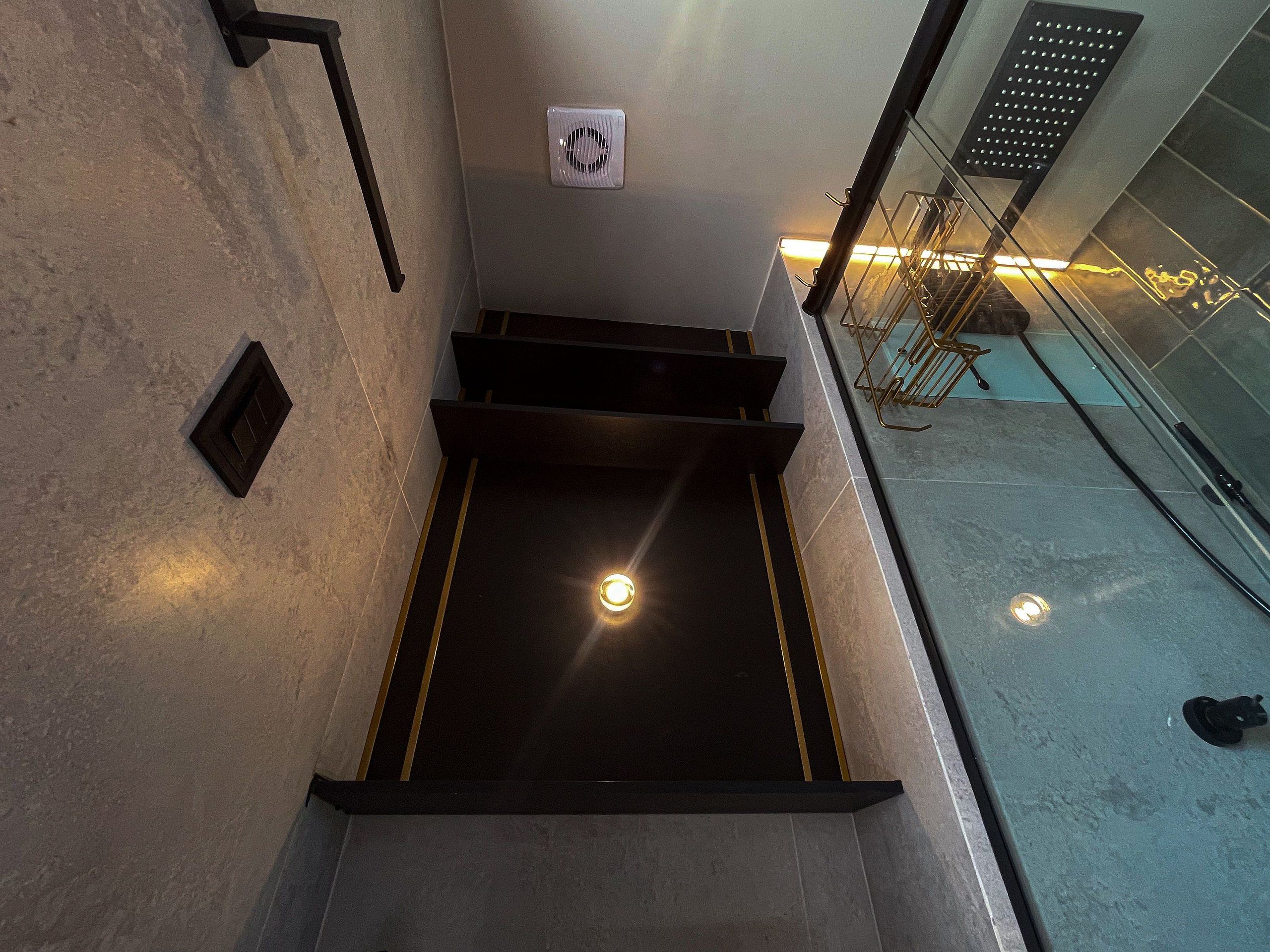 Una escalera con barandilla y una lámpara en la parte superior.