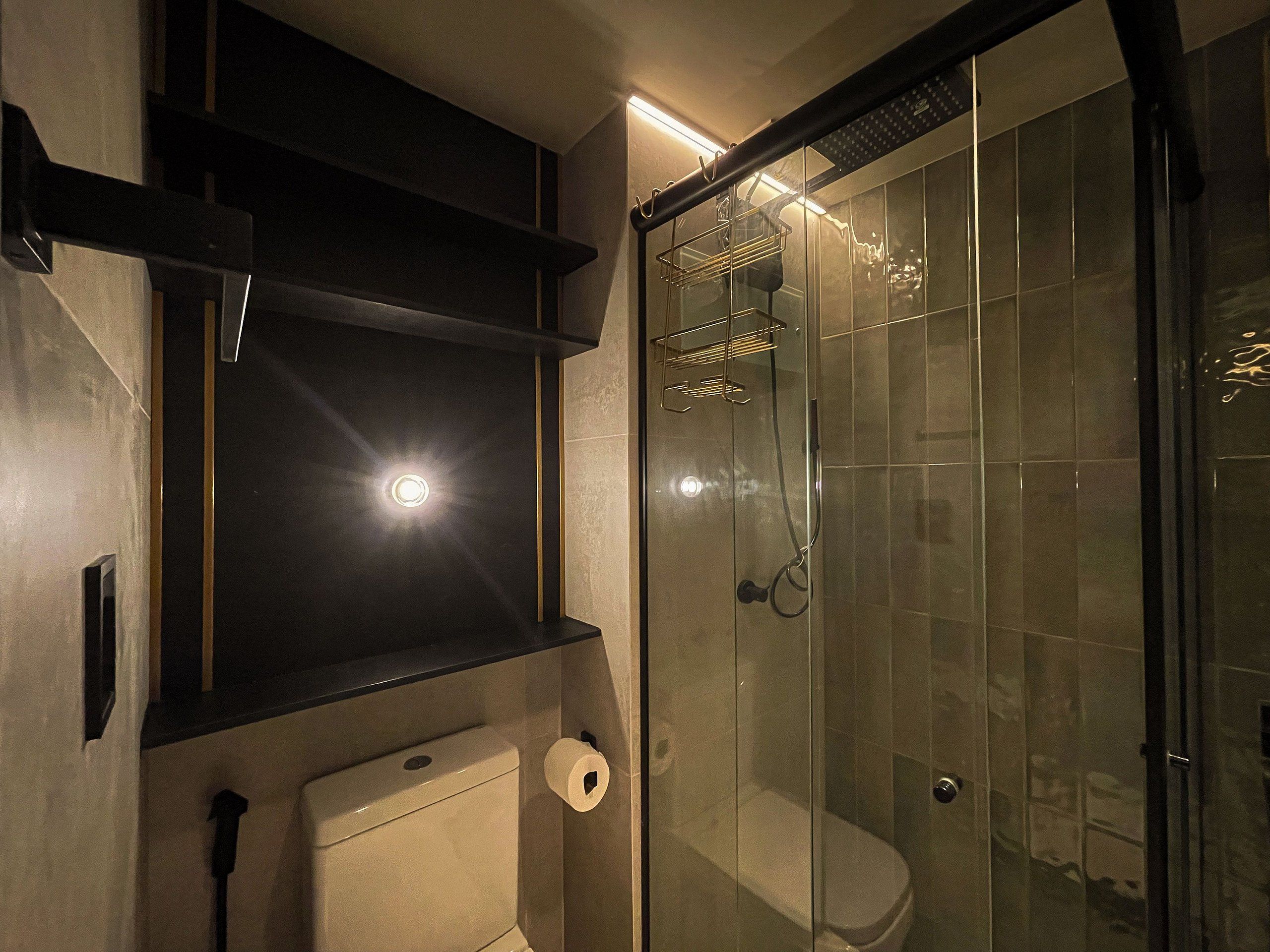 Un baño moderno con cabina de ducha de vidrio, inodoro y barra para toallas.