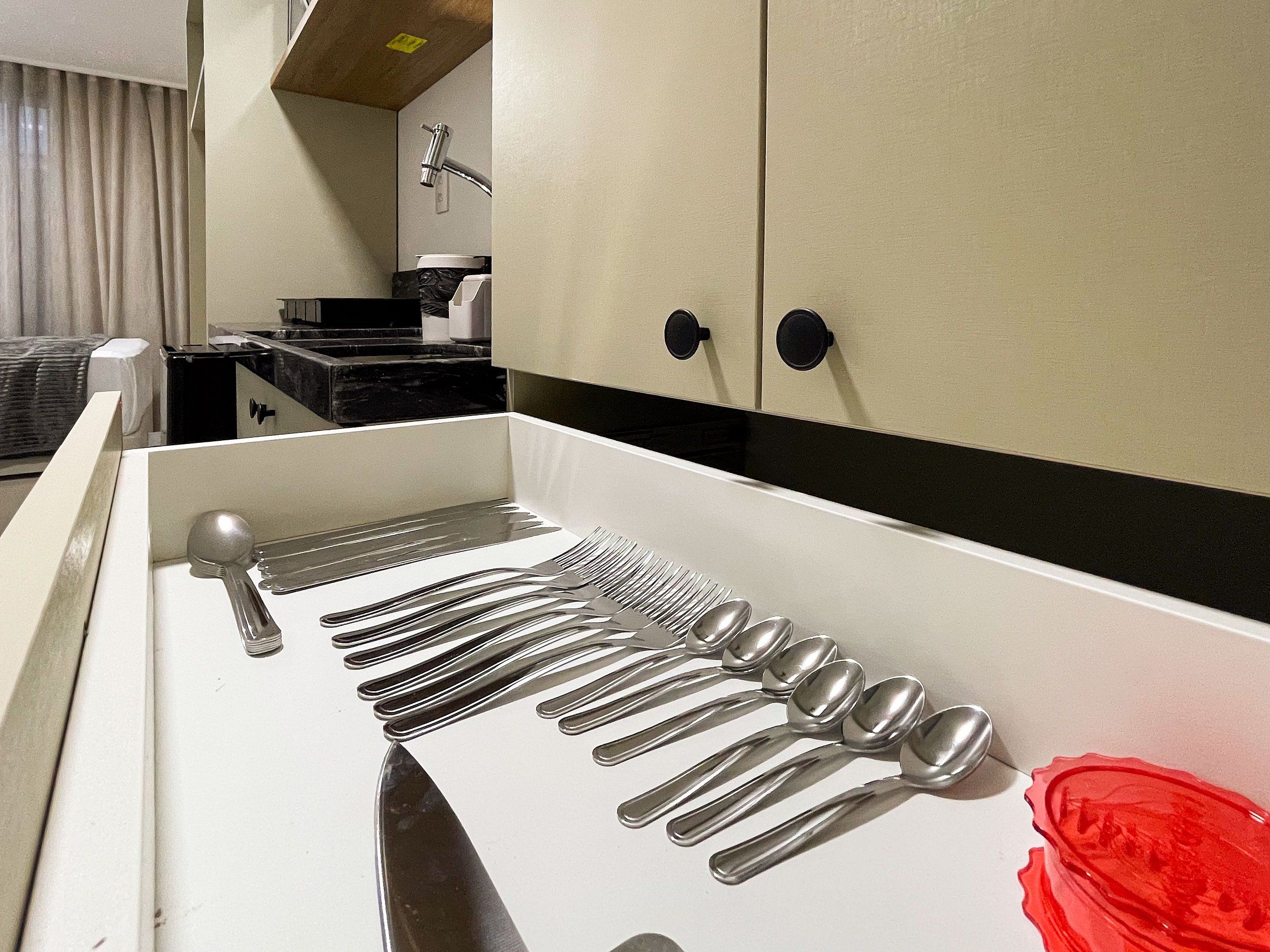 A kitchen with a utensil holder containing forks, knives, and spoons.