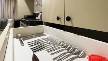 A kitchen with a utensil holder containing forks, knives, and spoons.