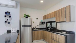 A modern kitchen with wooden cabinets, a stainless steel refrigerator, a microwave, and a sink. - Family oasis near the sea - La Cruz Encantada 2A (La Cruz de Huanacaxtle)