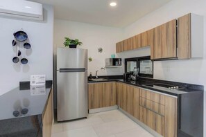 A modern kitchen with wooden cabinets, a stainless steel refrigerator, a microwave, and a sink. - Family oasis near the sea - La Cruz Encantada 2A (La Cruz de Huanacaxtle)