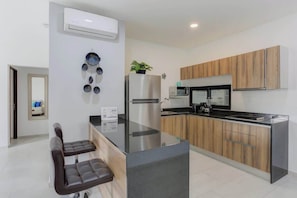 A modern kitchen with a central island, stainless steel appliances, and wooden cabinetry. - Family oasis near the sea - La Cruz Encantada 2A (La Cruz de Huanacaxtle)