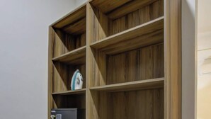 A built-in wooden wardrobe with multiple shelves and drawers, a small appliance, and a safe. - Family oasis near the sea - La Cruz Encantada 1A (La Cruz de Huanacaxtle)