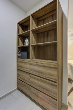 Ein integrierter Holzschrank mit mehreren Regalen und Schubladen, ein Haushaltsgerät und ein Safe.