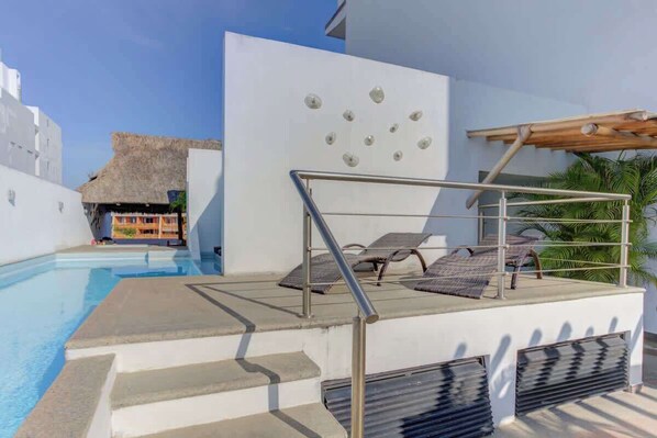 A pool area with steps leading down to the water, lounge chairs, and a pergola structure. - Family oasis near the sea - La Cruz Encantada 1A (La Cruz de Huanacaxtle)
