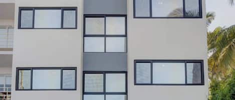 A modern multi-story building with large windows and a flat roof.