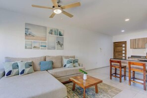 Ein modernes Wohnzimmer mit einer Couch, einem Couchtisch und einem Essbereich mit Stühlen.