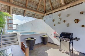 Ein Poolbereich auf dem Dach mit Grill und Steindekorationen.