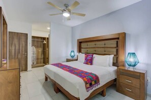 Ein Schlafzimmer mit einem Bett, Nachttischen, einem Deckenventilator und einem Kleiderschrank.