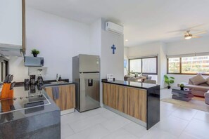 A modern kitchen with a built-in island, a refrigerator, and a microwave. - Family oasis near the sea - La Cruz Encantada 3B (La Cruz de Huanacaxtle)