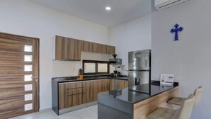 A modern kitchen with a central island, wooden cabinets, and a stainless steel refrigerator. - Family oasis near the sea - La Cruz Encantada 3B (La Cruz de Huanacaxtle)
