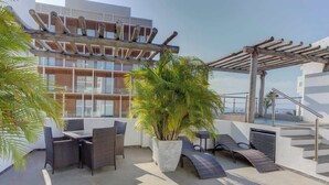 A rooftop terrace with outdoor furniture, a large potted plant, and a pergola. - Family oasis near the sea - La Cruz Encantada 3B (La Cruz de Huanacaxtle)