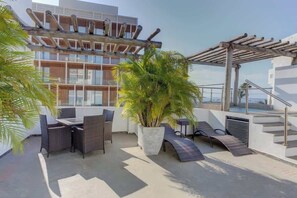 A rooftop terrace with outdoor furniture, a large potted plant, and a pergola. - Family oasis near the sea - La Cruz Encantada 3B (La Cruz de Huanacaxtle)