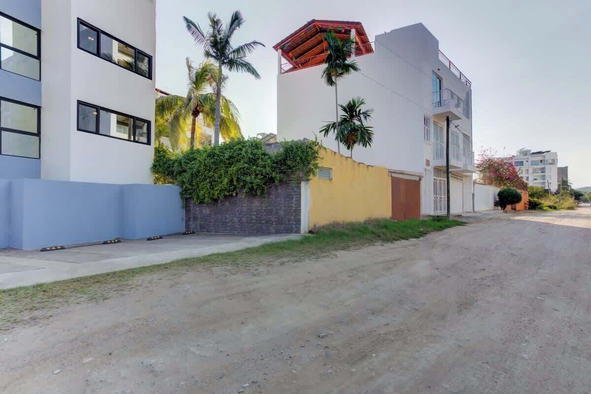 Um edifício moderno com telhado plano, janelas amplas e um caminho de acesso pavimentado.