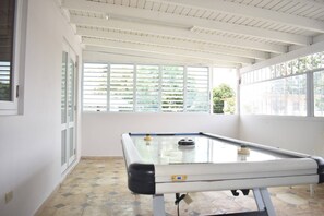 A pool table in a room with large windows and a tiled floor. - Villa Aerio (Carolina)