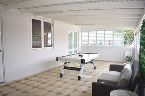 A pool table in a room with a tiled floor, white walls, and a ceiling with exposed beams. - Villa Aerio (Carolina)