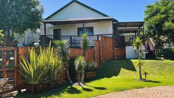 A residential property with a fenced yard, a covered patio, and a paved driveway.